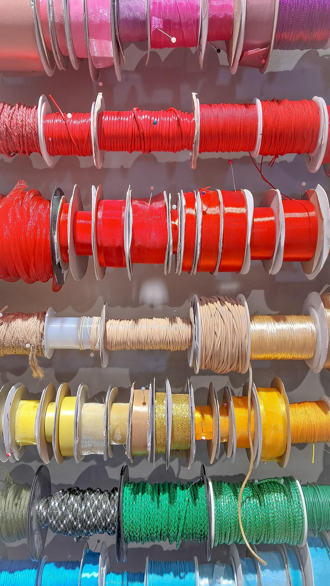 Close-up of embroidered sampler with threads and needles